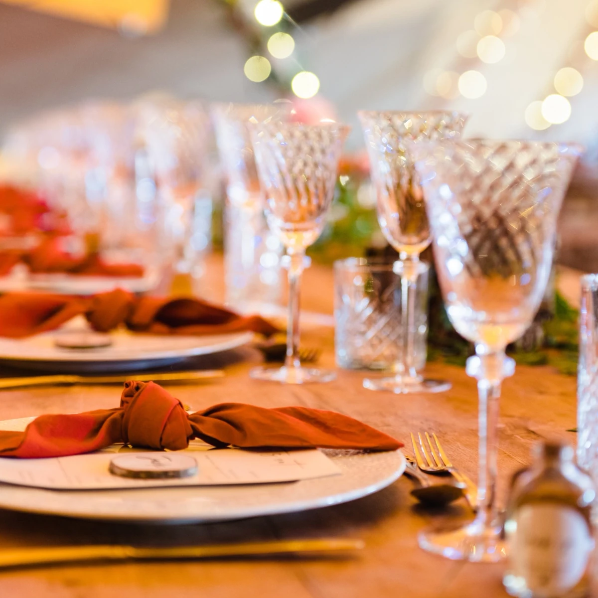 Festive dining table set with plates, folded napkins, cutlery and crystal glasses