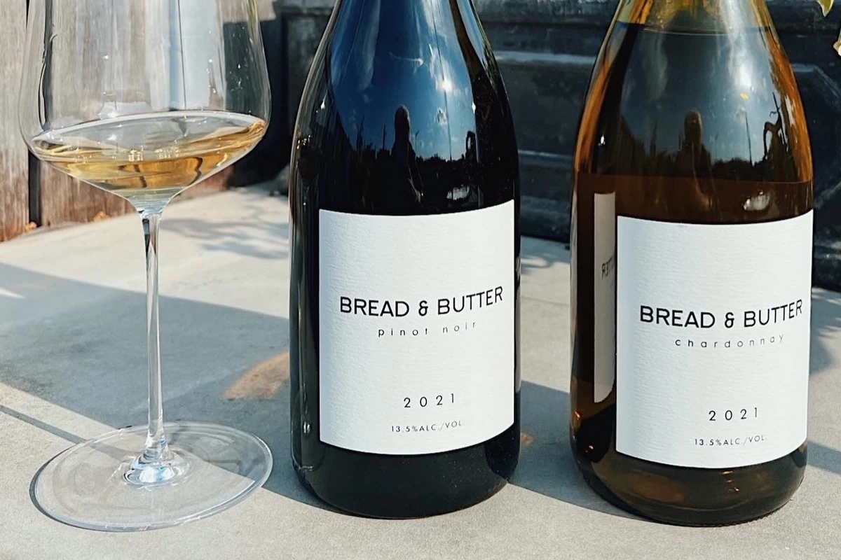 Wine glass beside Bread & Butter Pinot Noir and Chardonnay bottles, 2021