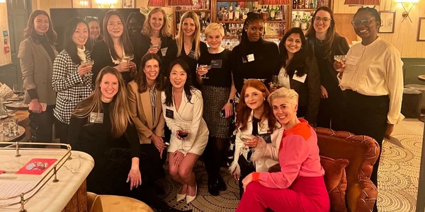 Group of women posing with wine glasses in a bar