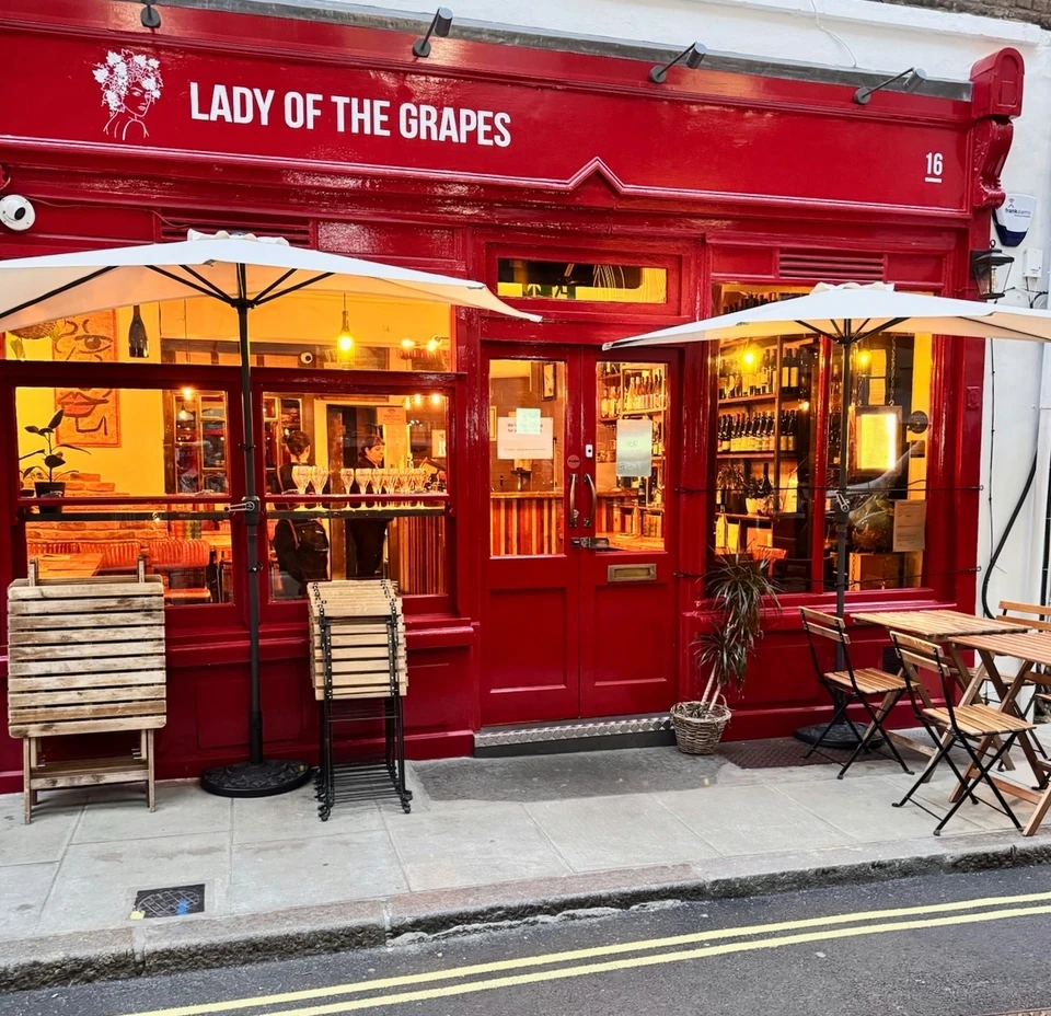 Red Lady of the Grapes wine bar frontage with outdoor tables and umbrellas