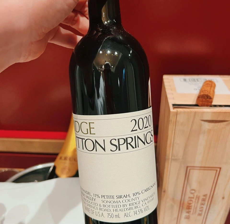 Bottle of Ridge Lytton Springs 2020 held beside a wooden wine box