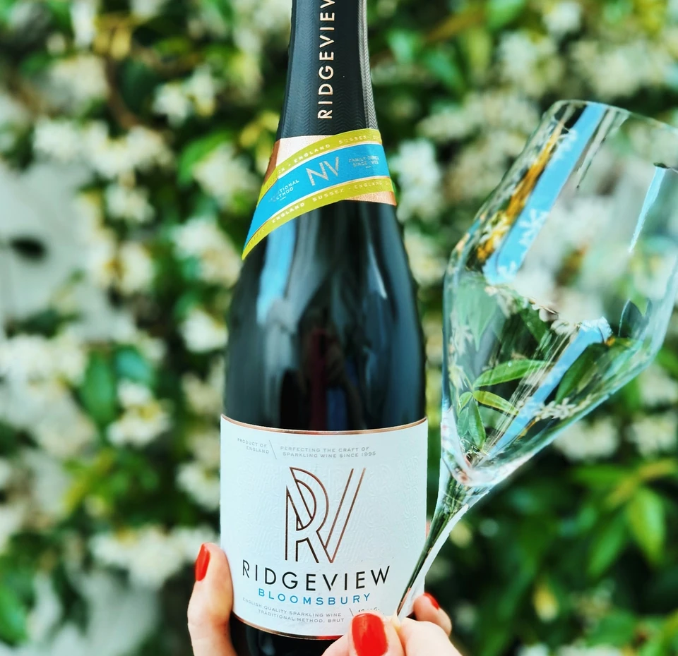 Ridgeview sparkling wine bottle held beside a filled wine glass