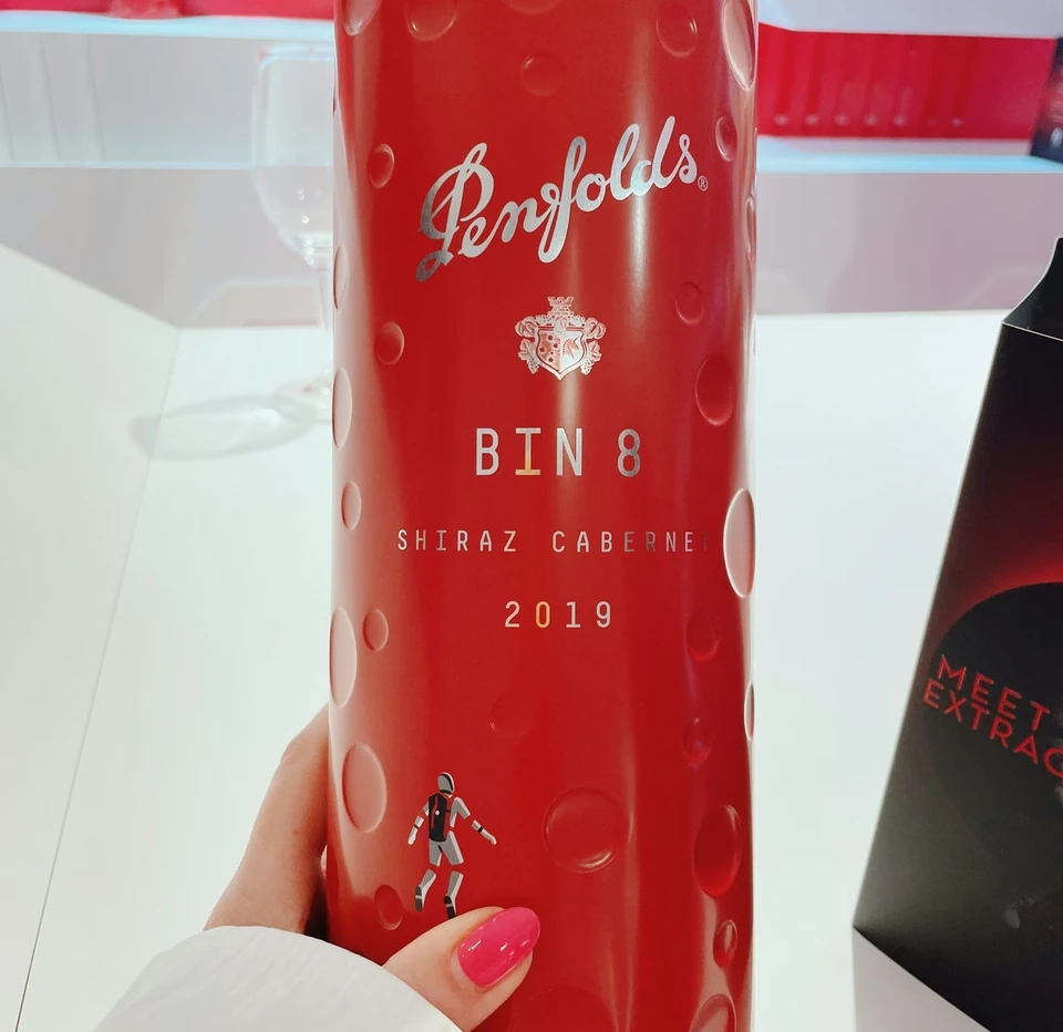 Penfolds Bin 8 Shiraz Cabernet 2019 bottle held in front of a red wine display