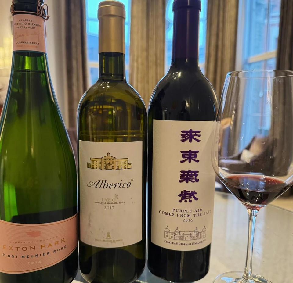 Exton Park Pinot Meunier bottle beside two other wine bottles and a glass of red wine