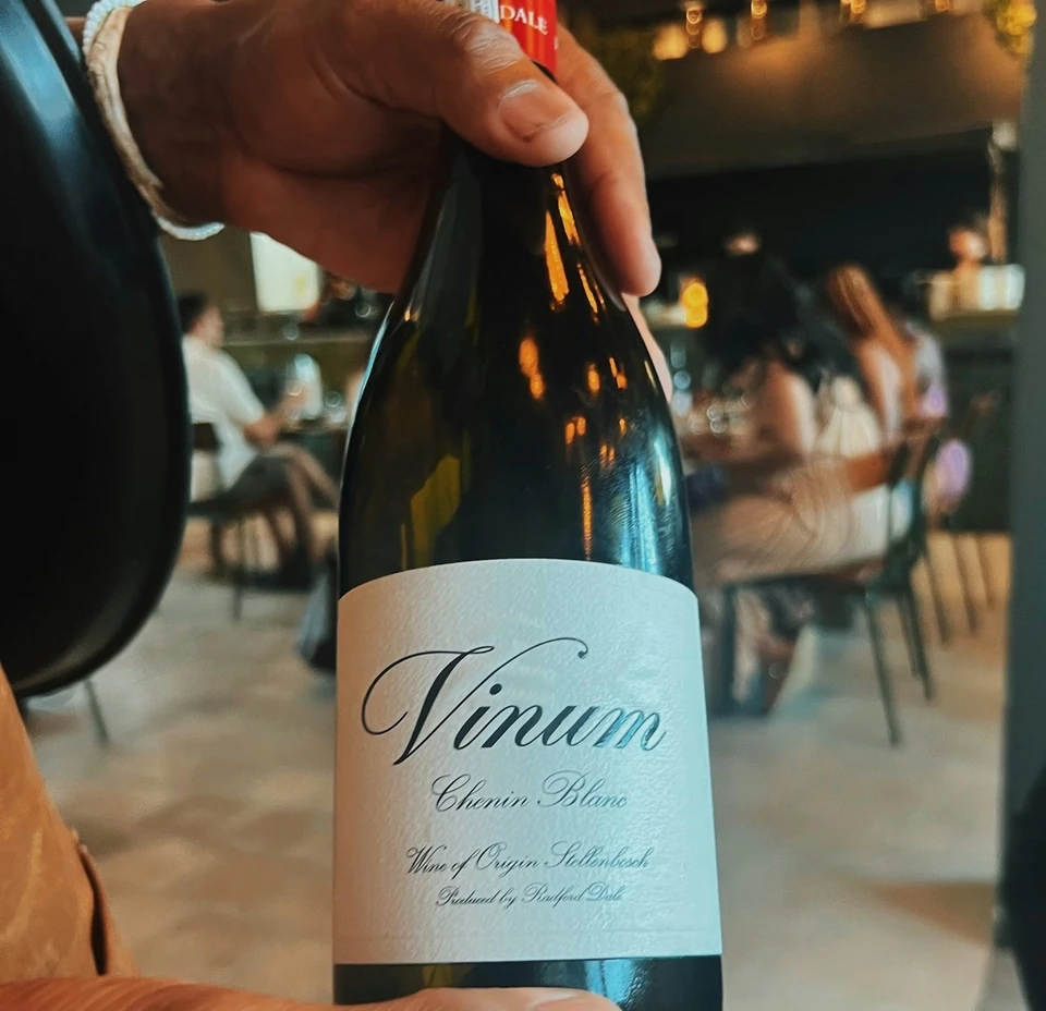 Vinum Chenin Blanc bottle from Stellenbosch held during a restaurant tasting