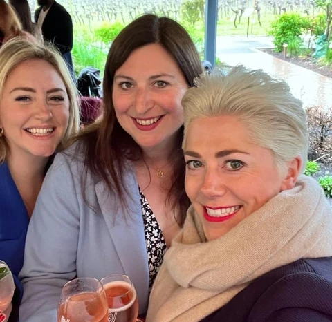 Three women holding glasses of rosé during a Ridgeview vineyard visit