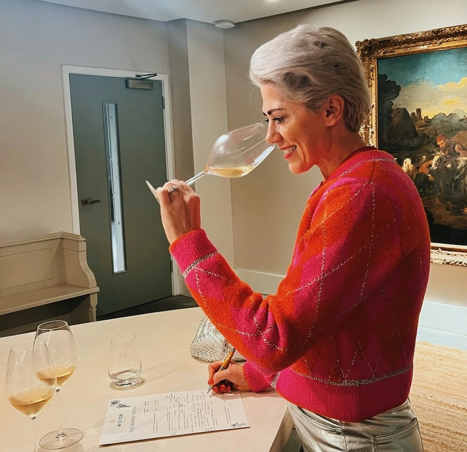 Woman tasting wine and writing notes at a Wiston tasting table