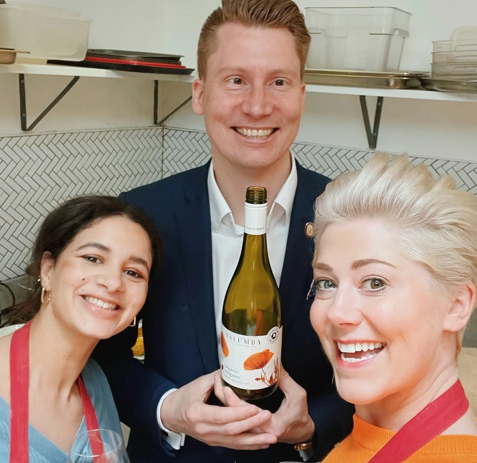 Three people pose with a bottle of Yalumba Organic Viognier and a glass of white wine