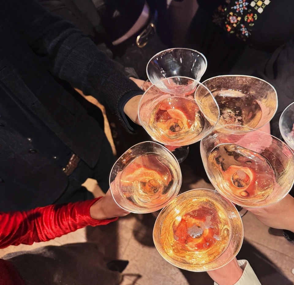 Guests raise glasses of sparkling wine at a Folc wine tasting