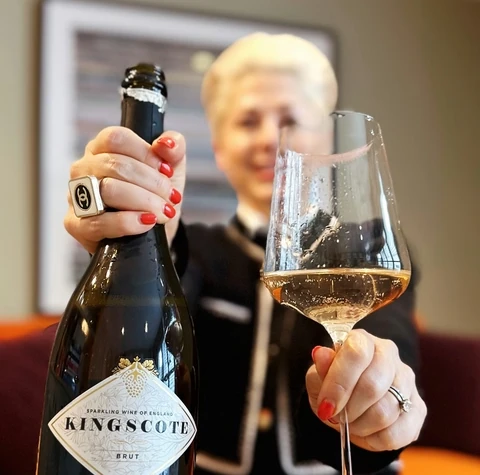 Kingscote Brut English sparkling wine bottle and filled tasting glass held during a tasting