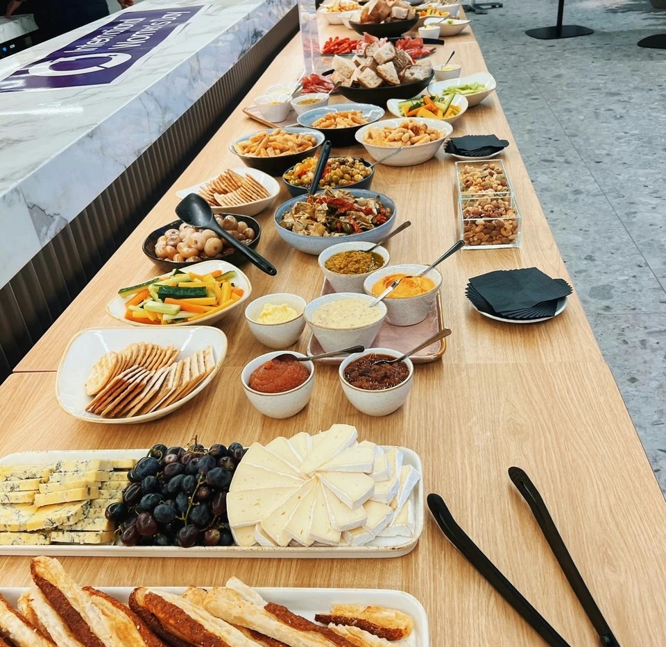 Buffet table with cheeses, bread, dips, crudités, crackers, fruit and savoury snacks