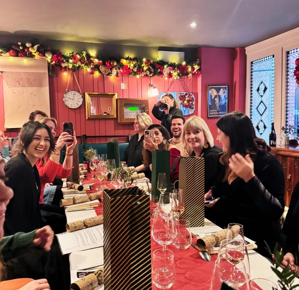 Guests enjoy a festive wine tasting around a decorated dining table