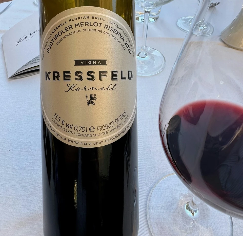 Kressfeld Kornell Südtiroler Merlot Riserva 2020 bottle beside a glass of red wine