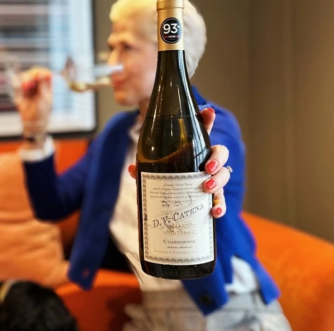 D.V. Catena Chardonnay bottle held in front of a seated wine taster