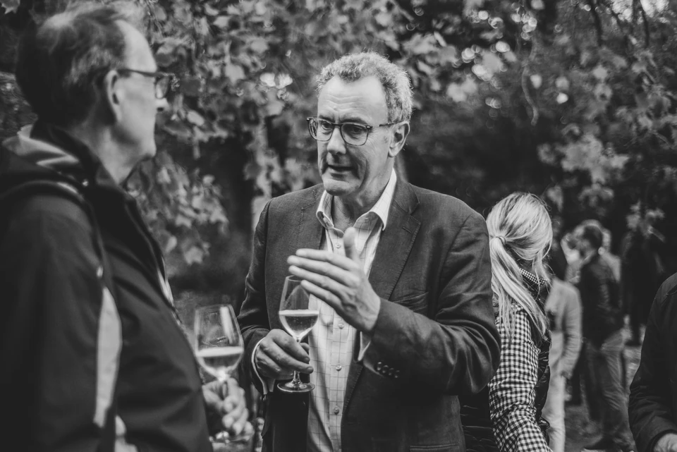 Guests converse over wine at an outdoor networking event