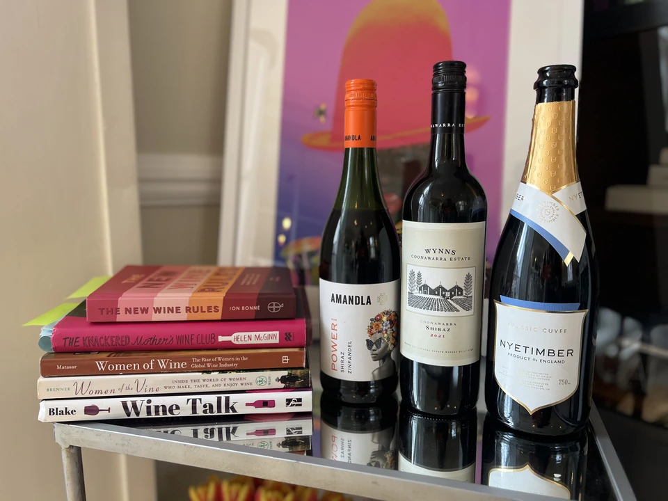 Nyetimber sparkling wine bottle beside two wine bottles and books about women in wine