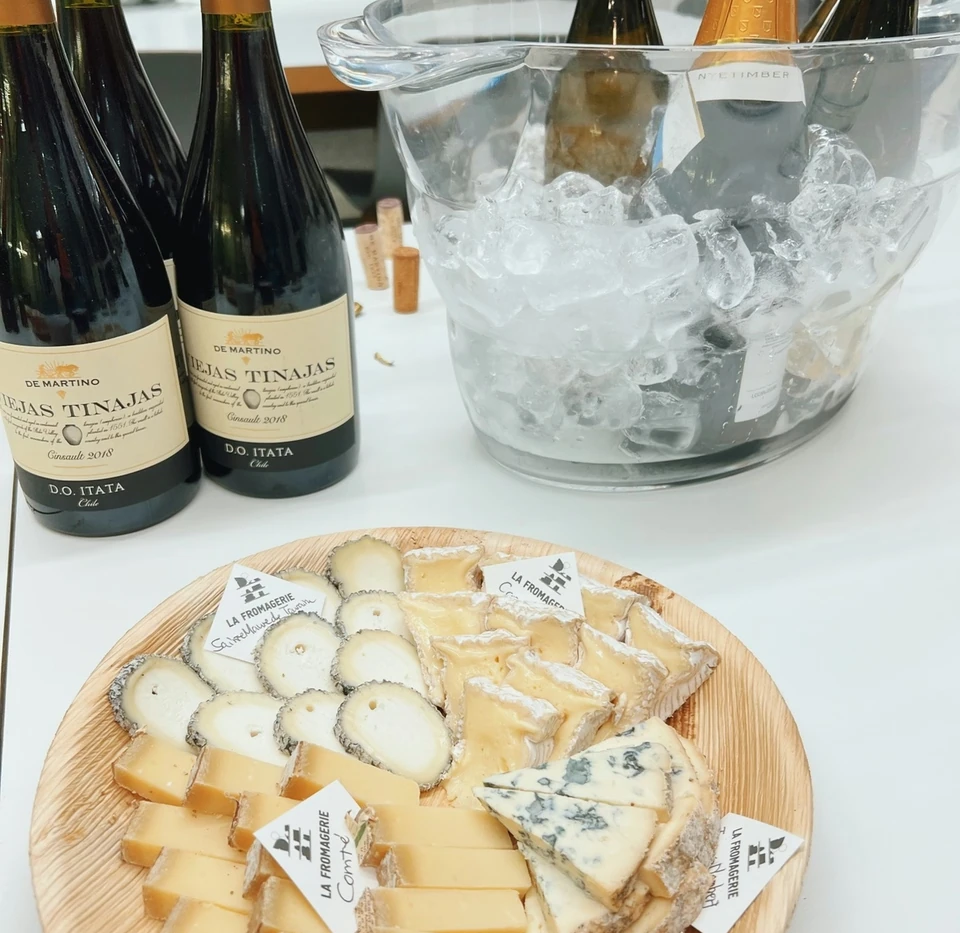 Chilean wine bottles in an ice bucket beside a platter of assorted cheeses