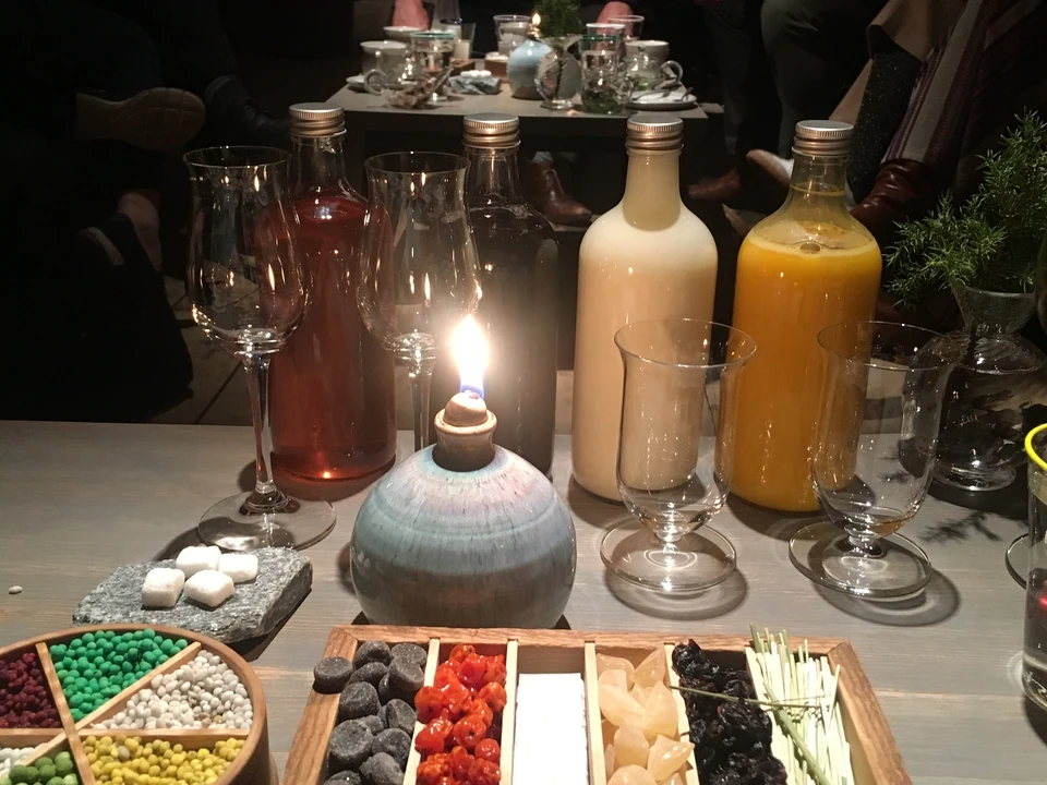 Blind wine tasting table with covered bottles, wine glasses and colourful tasting accompaniments