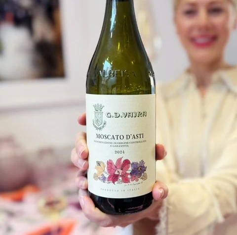 Bottle of G.D. Vajra Moscato d’Asti held in front of a woman