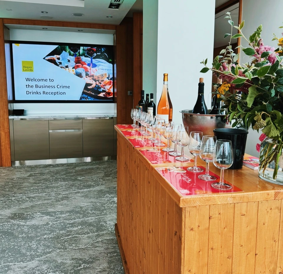 Wine tasting table with glasses and bottles at Hogan Lovells' Business Crime Drinks Reception