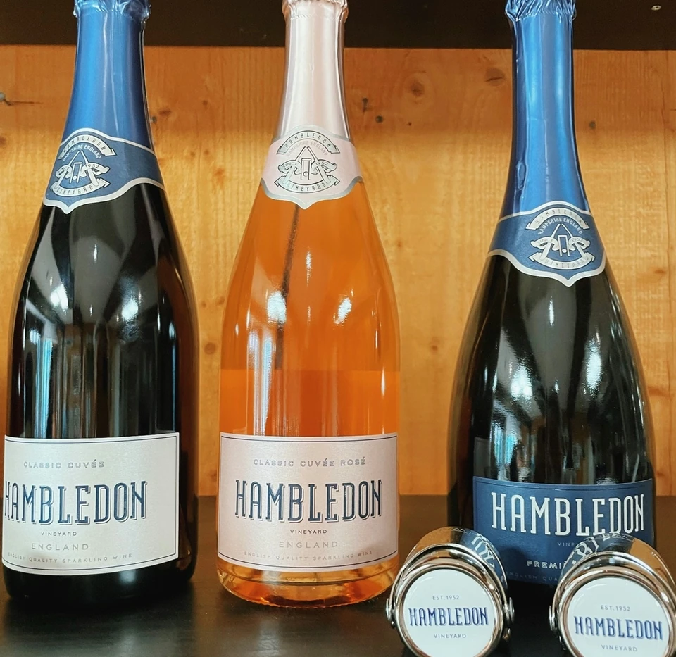 Three Hambledon sparkling wine bottles with branded bottle stoppers