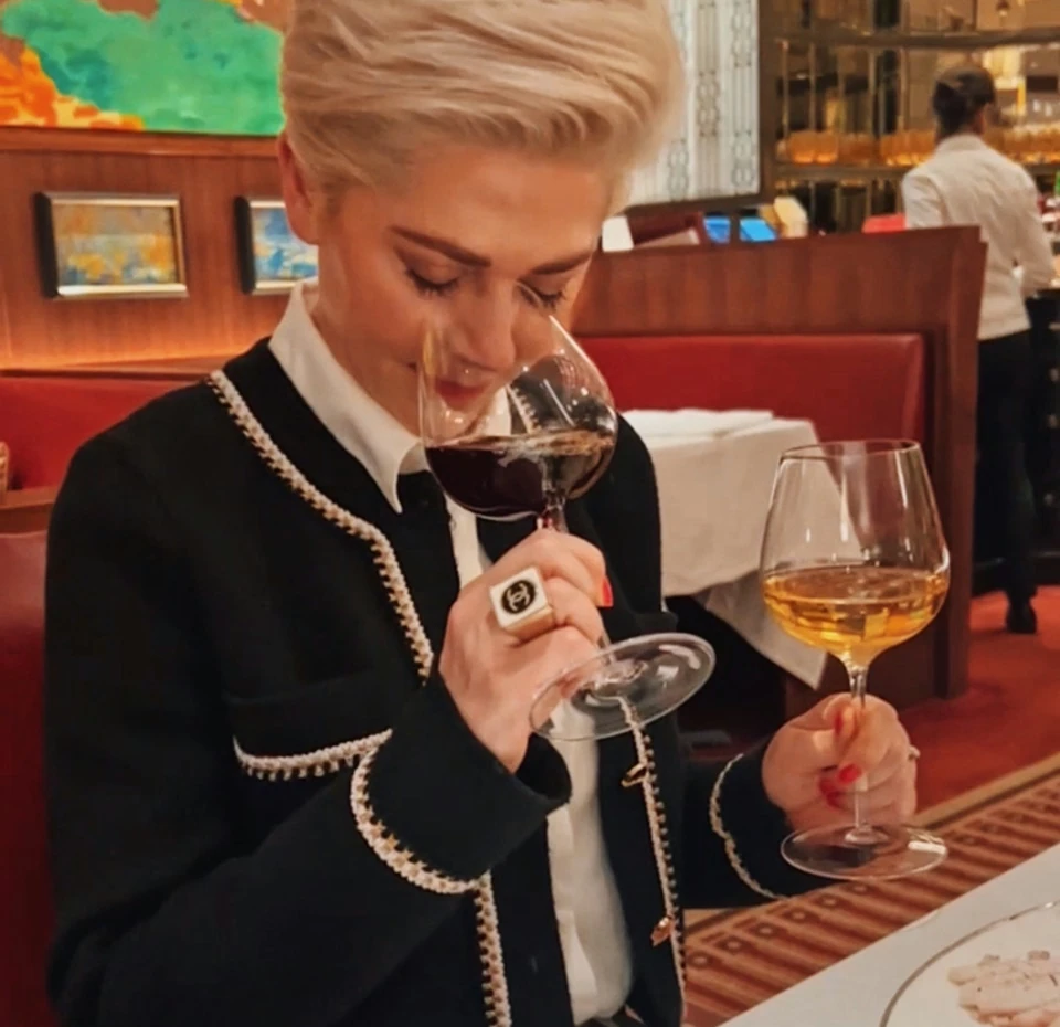 Diner smelling wine at a restaurant table in The Colony Grill Room