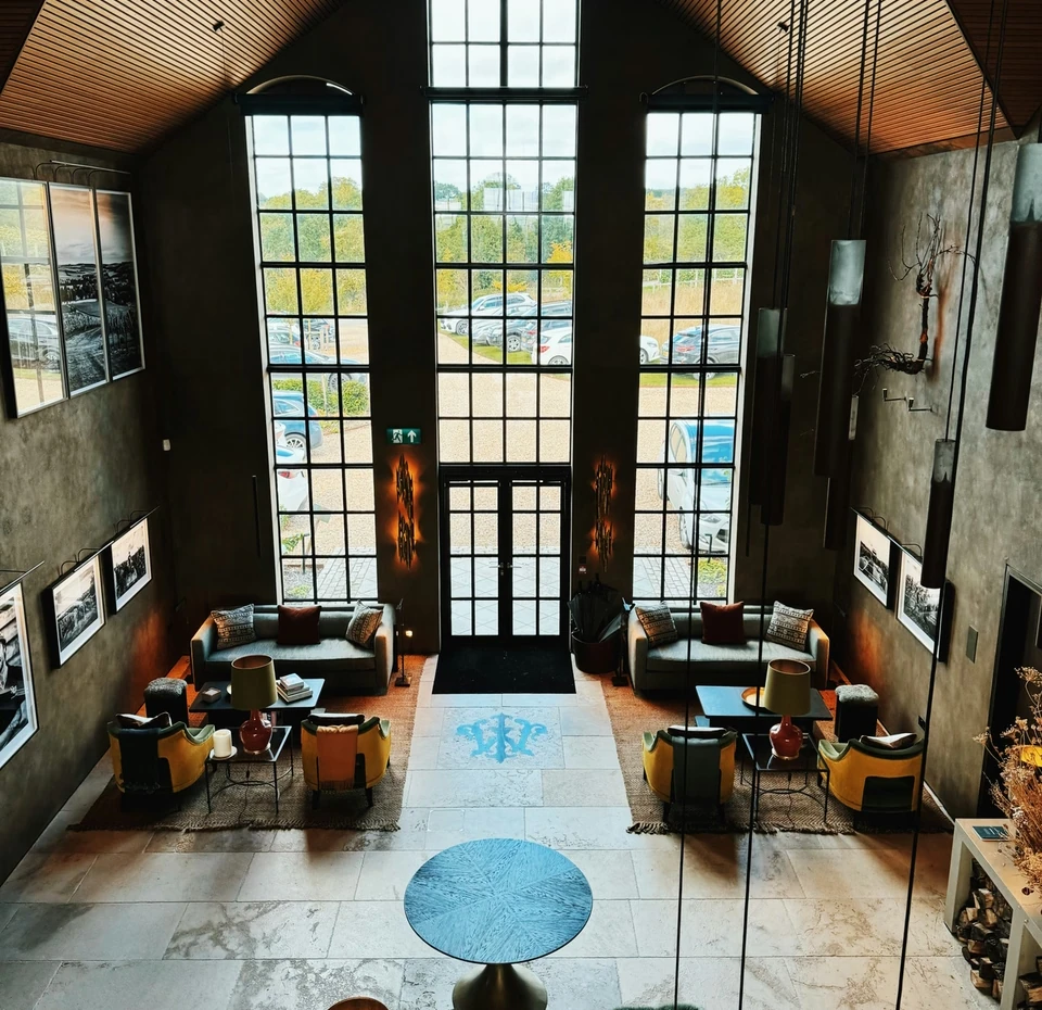Exton Park winery reception with tall windows, framed photographs, sofas and colourful lounge chairs