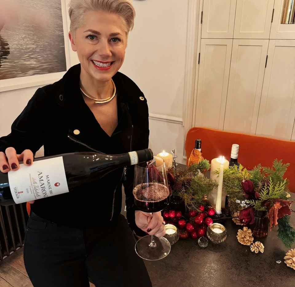 Tedeschi Amarone red wine is poured beside a festive table setting