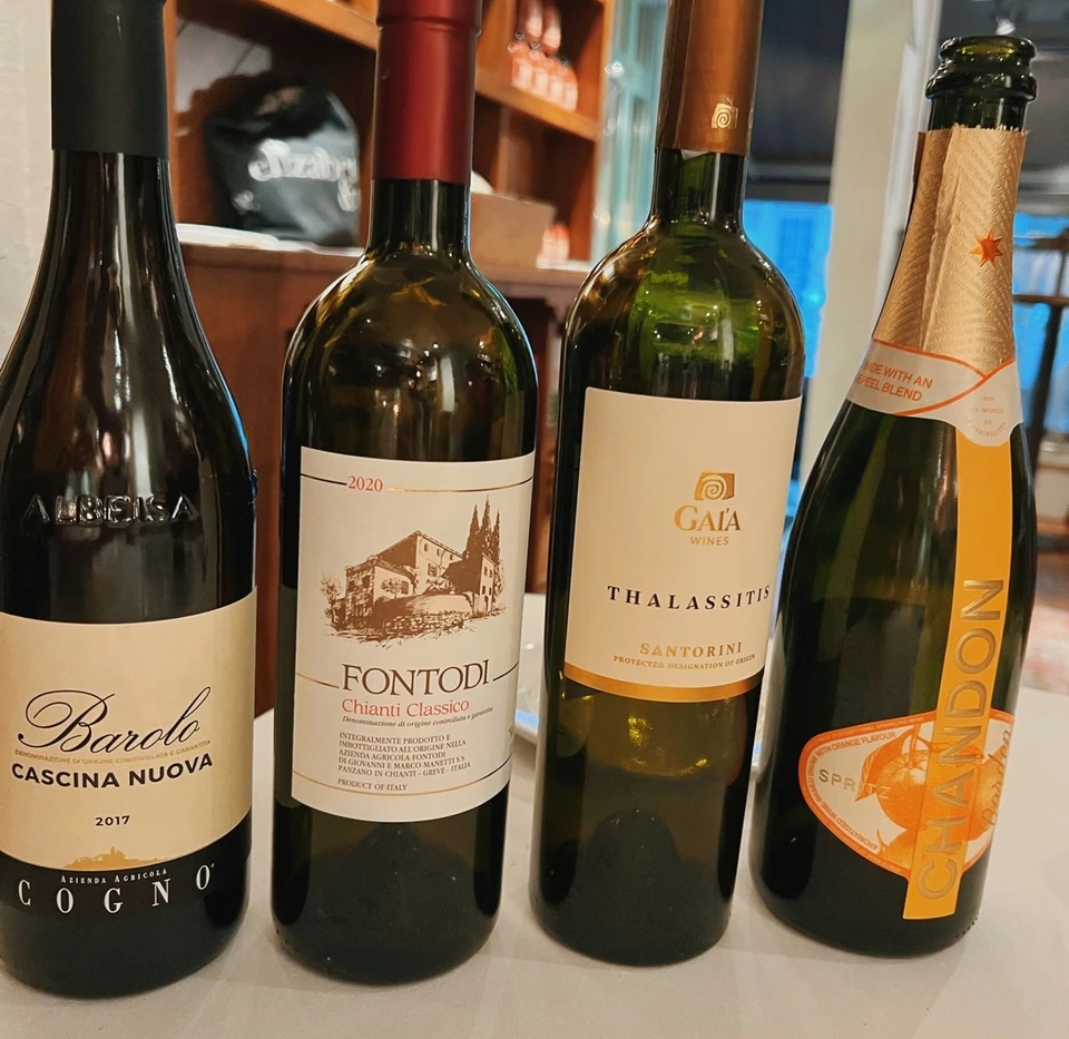 Barolo and three other wine bottles displayed on a tasting table
