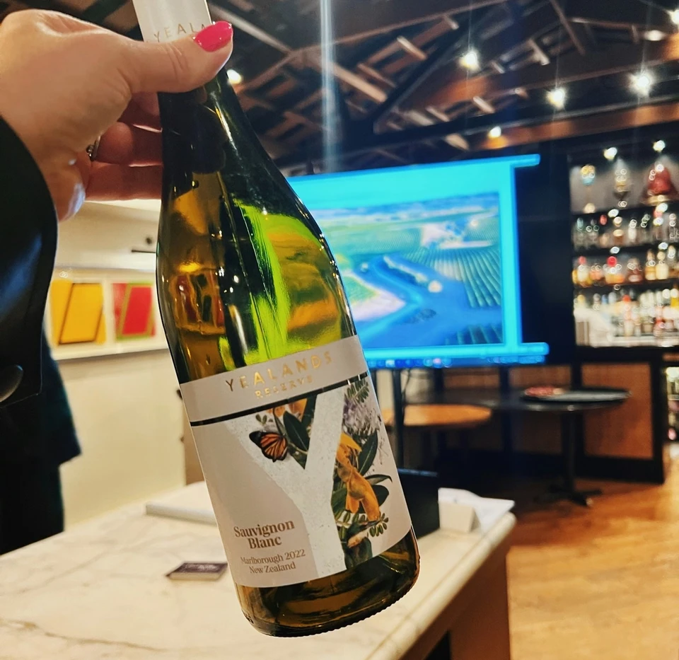 Hand holding a Yealands Sauvignon Blanc bottle in a bar
