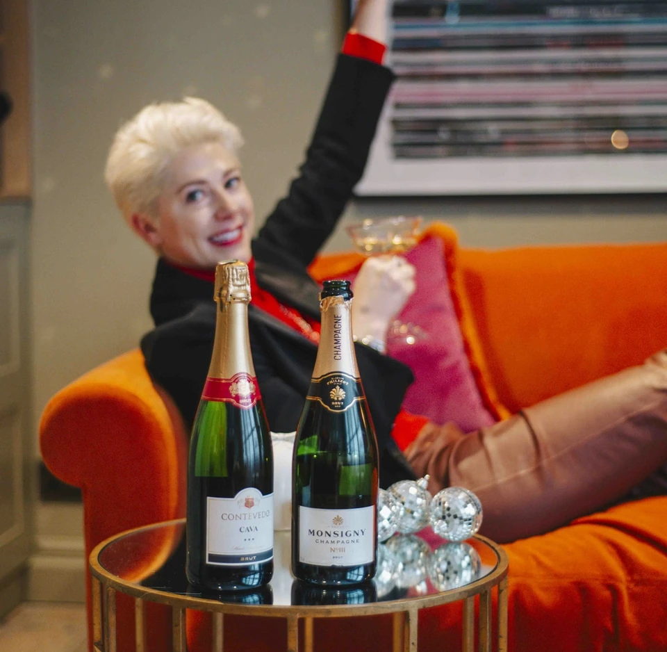 Contevedo Cava and Monsigny Champagne bottles beside a person holding a disco ball