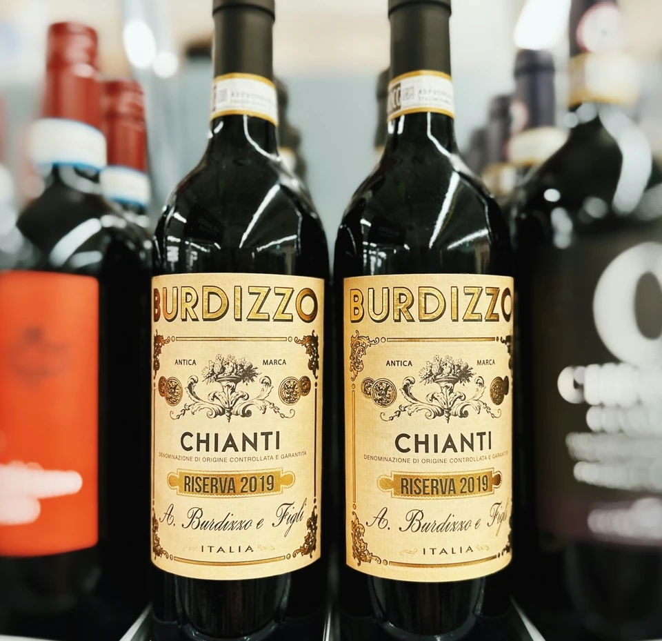 Two Burdizzo Chianti Riserva 2019 wine bottles displayed among other bottles