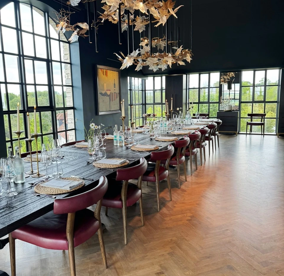 Dining room prepared for an Exton Park wine tasting, with glasses, candles and a long table beside tall windows