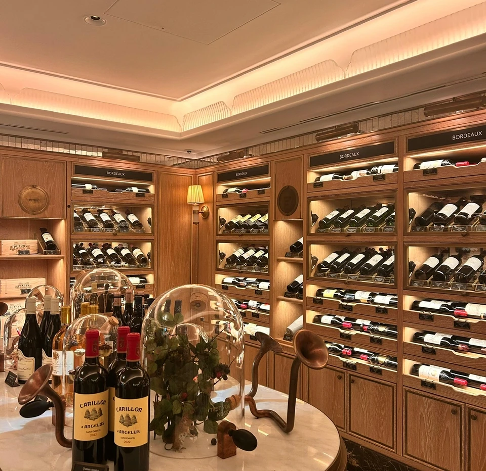 Bordeaux wine bottles displayed around a marble tasting table in an elegant wine room