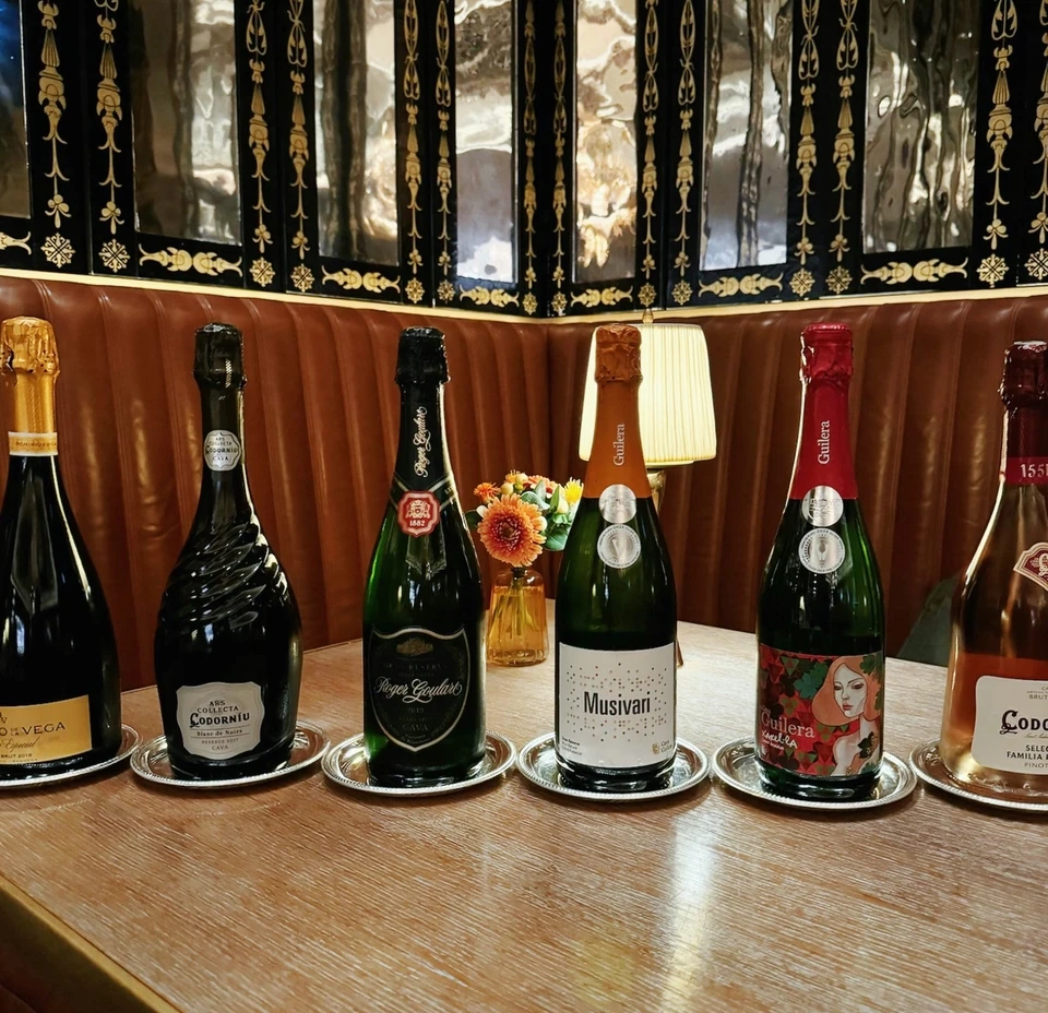 Selection of Cava bottles displayed on silver trays in a restaurant booth