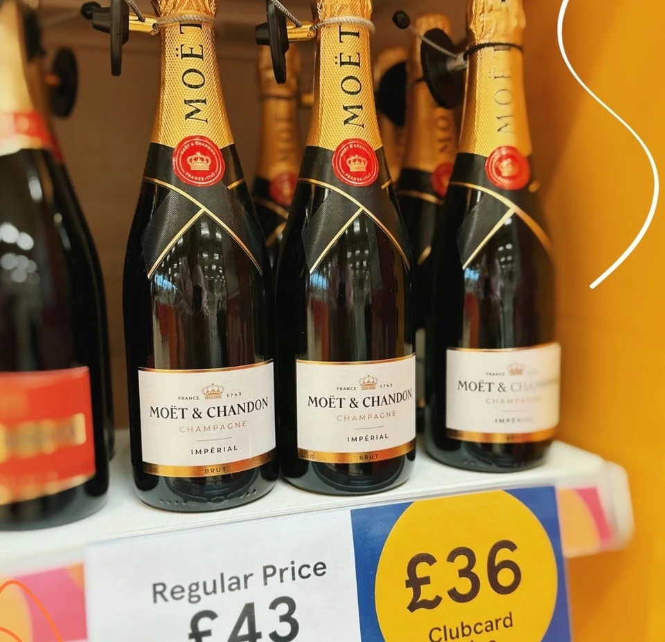 Moët & Chandon Champagne bottles on a Tesco shelf with Clubcard pricing