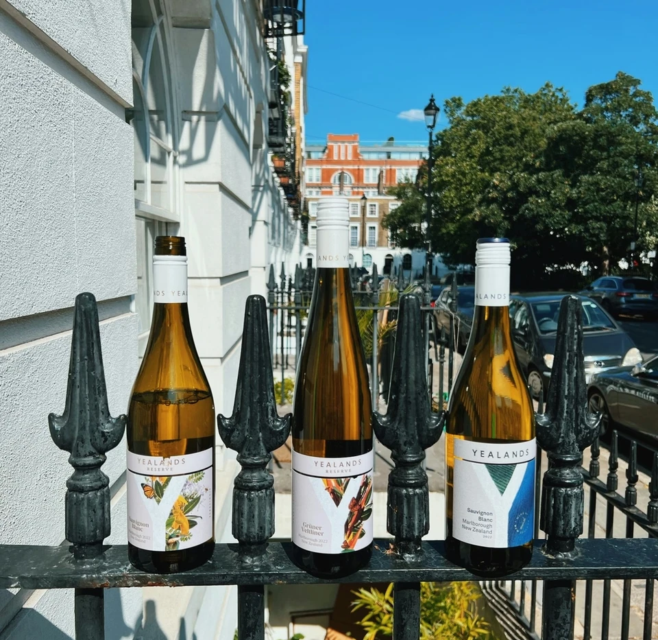 Three Yealands New Zealand wine bottles displayed on London railings in bright sunshine