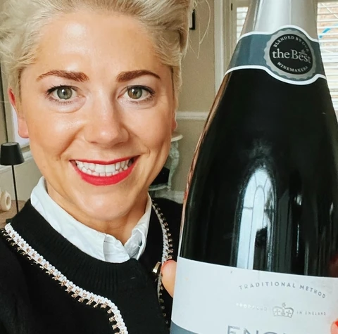 A woman holds a bottle of Morrisons The Best Grand Vintage 2010 Brut English sparkling wine