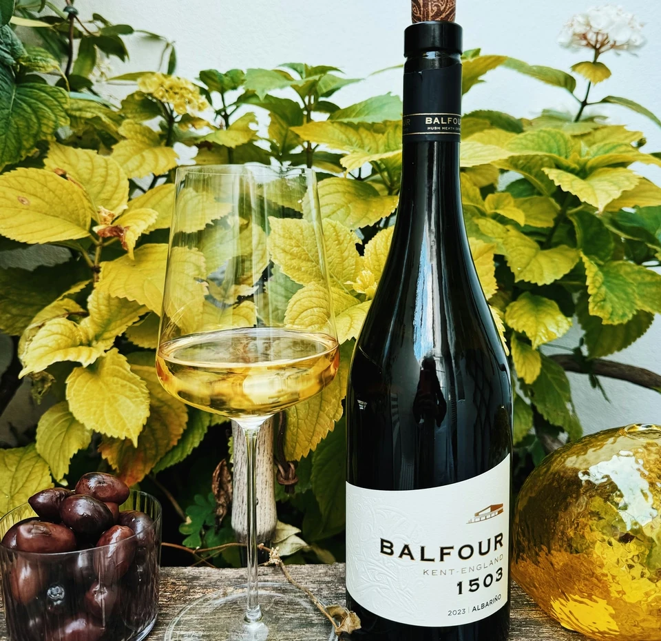 Balfour 1503 Albariño beside a glass of wine, olives and a golden decorative bottle