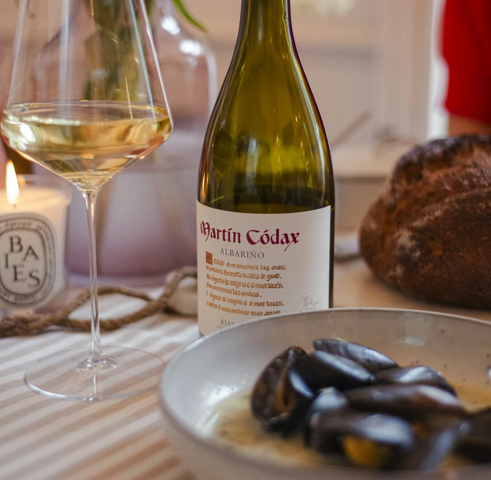 Martín Códax Albariño beside a glass of white wine and seafood