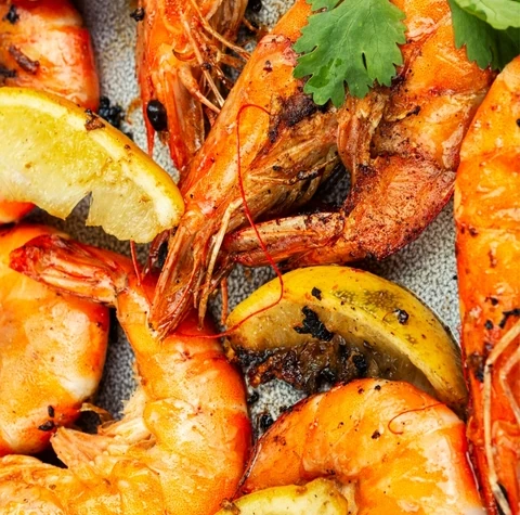Grilled prawns with lemon wedges and parsley