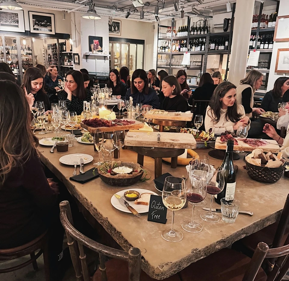 Guests enjoy a wine tasting with charcuterie and cheese in a farm shop