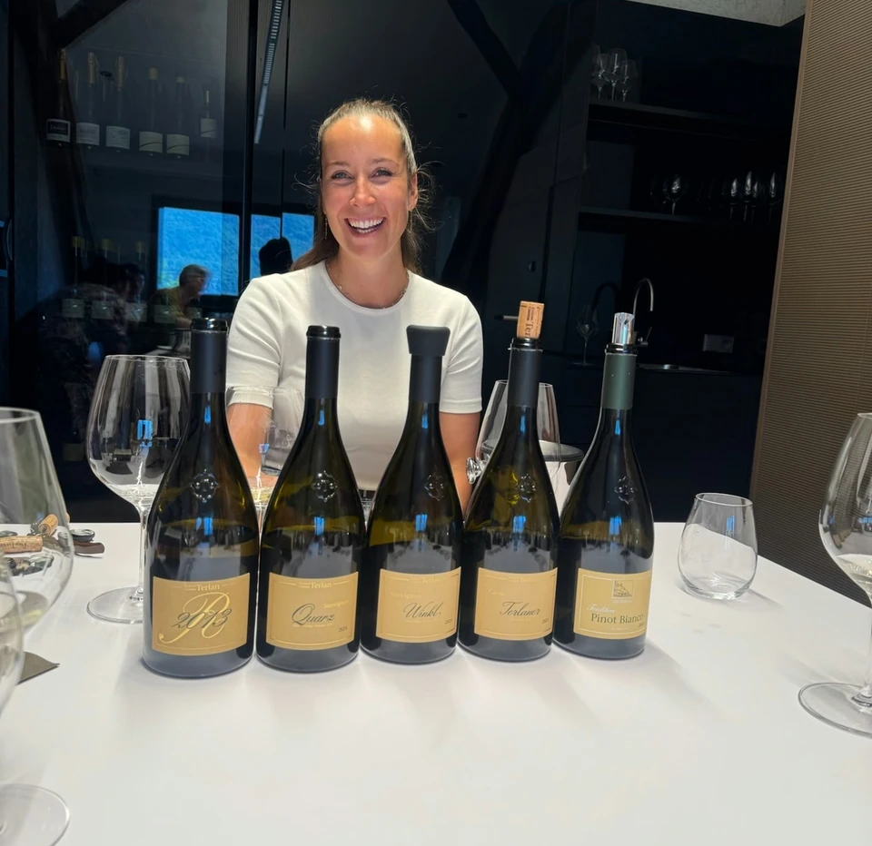 Wine educator standing behind five Terlan wine bottles at an Alto Adige tasting