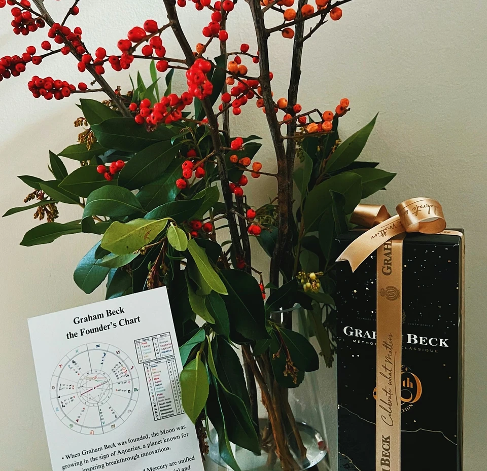 Graham Beck anniversary gift box beside a vase of red and orange berries