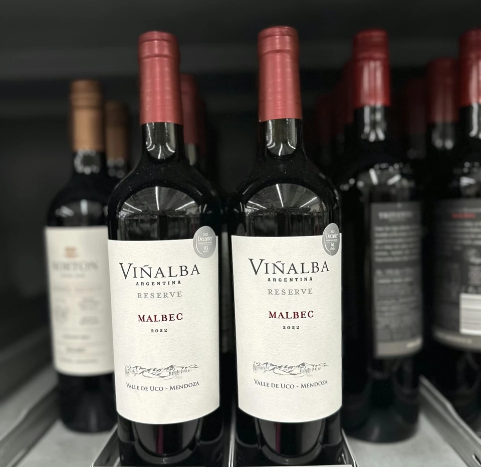 Two Vinalba Reserve Malbec bottles on a supermarket shelf