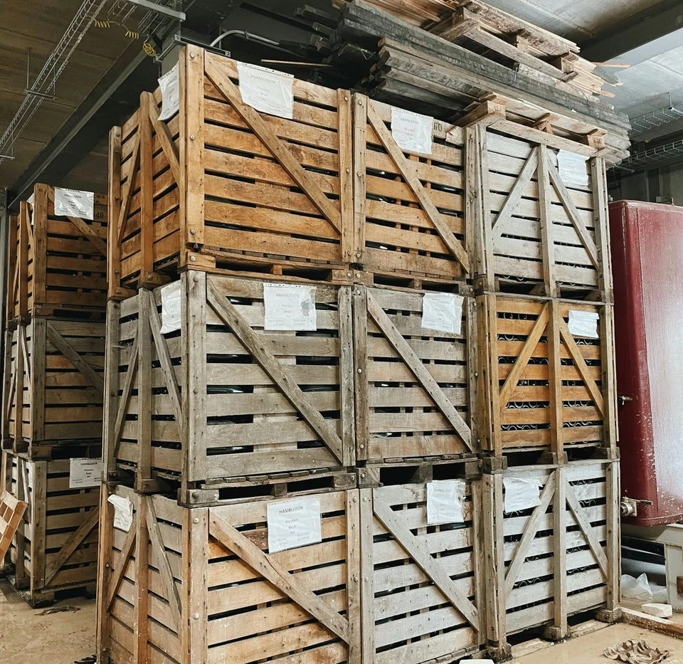 Stacked wooden wine crates labelled Hambledon in a winery storage area