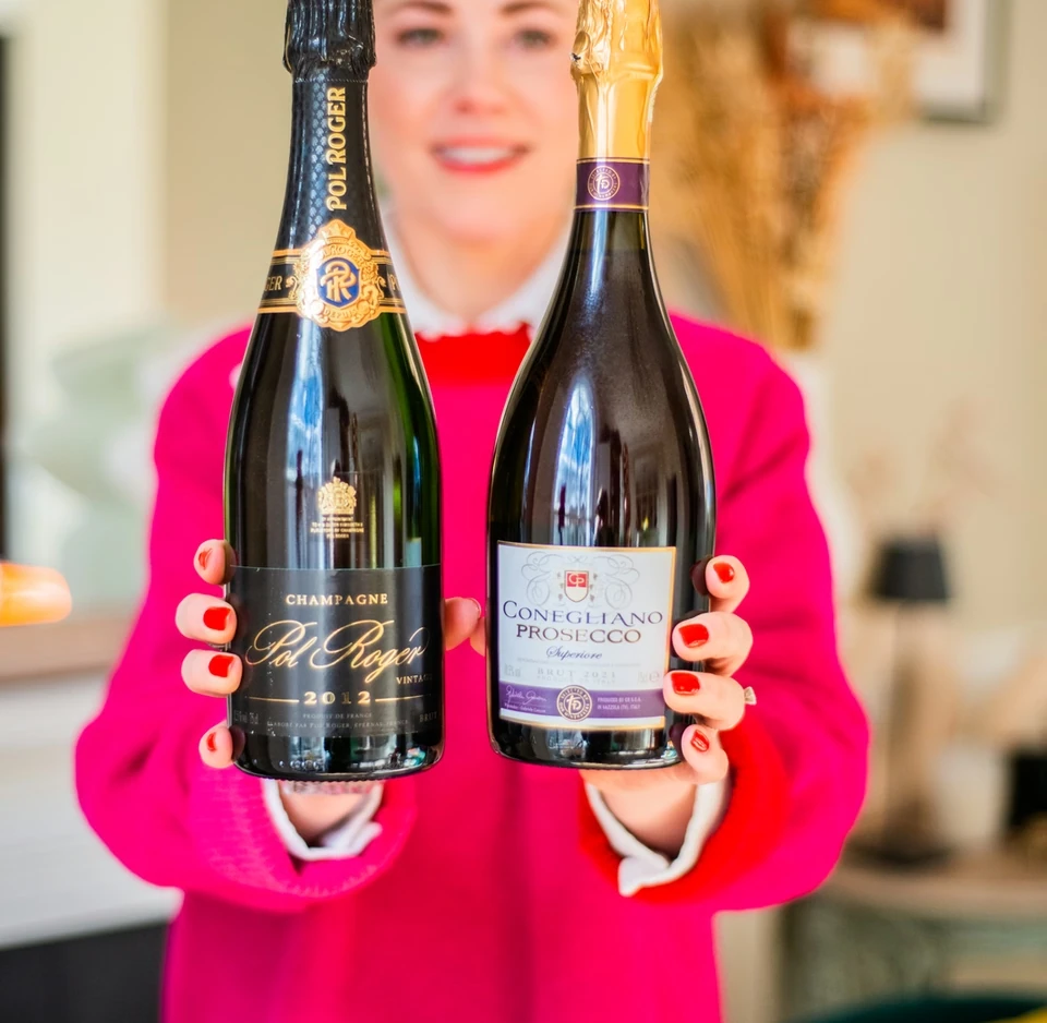 Woman holding bottles of Pol Roger Champagne and Conegliano Prosecco
