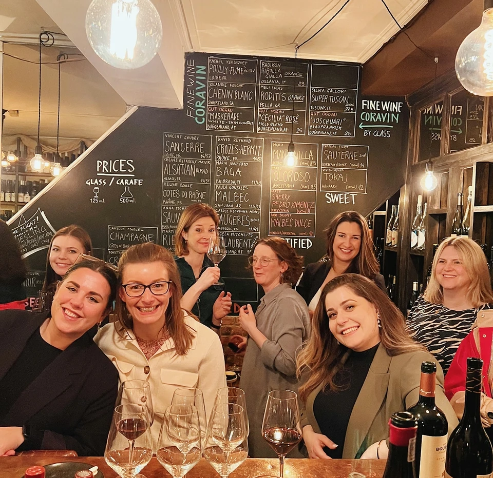Women tasting wine at a bar with wine glasses and bottles