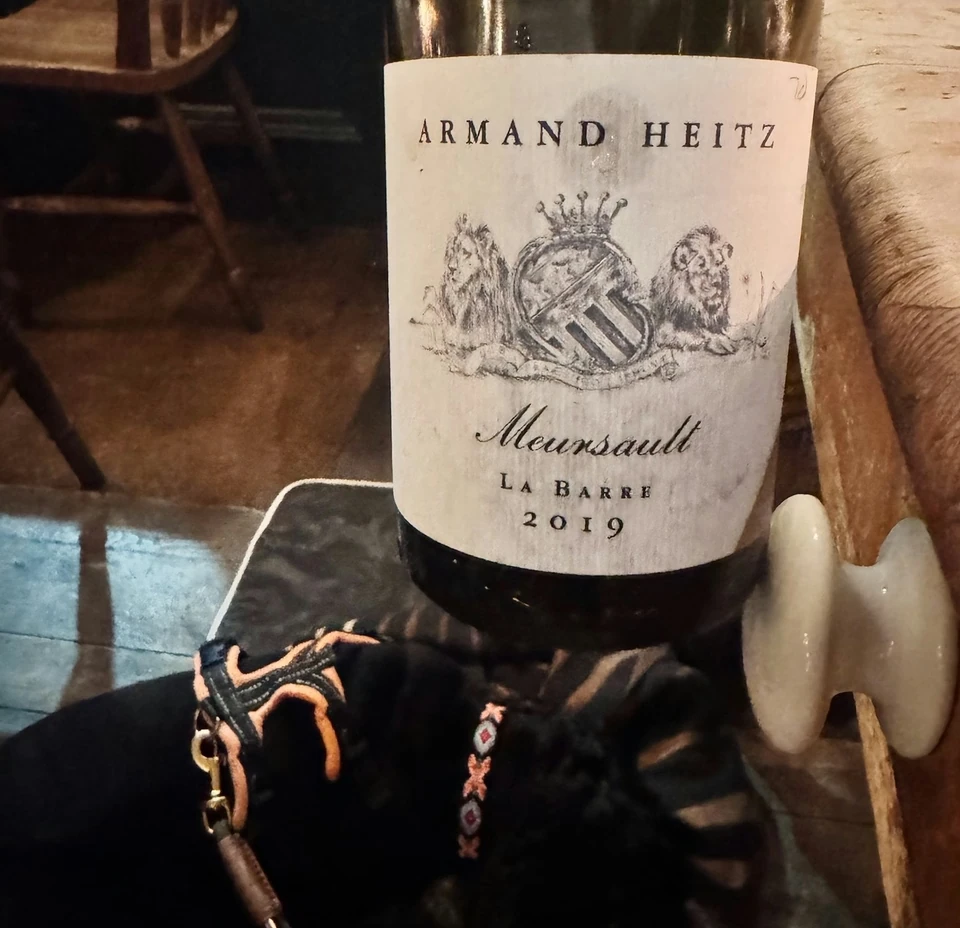 Armand Heitz Meursault La Barre 2019 wine bottle beside a small black dog