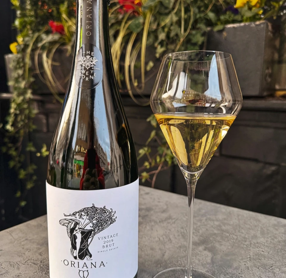 Oriana vintage 2019 sparkling wine beside a glass of golden wine